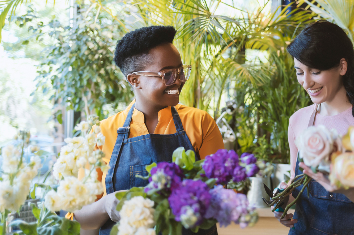 Portrait of Two Young Multiethnic Women Arranging Floral Compositions While Working in Flower Shop